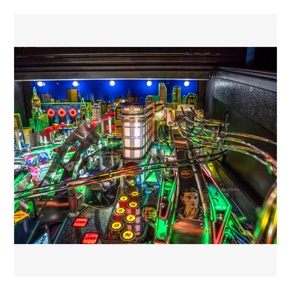Close-up of a pinball machine with colorful lights and cityscape background