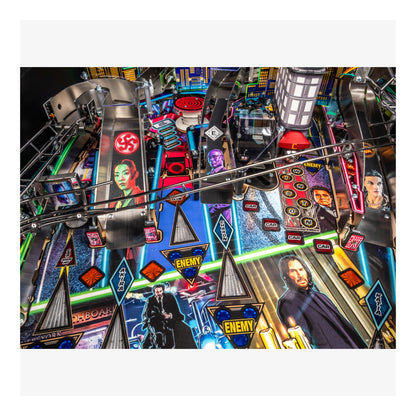 Close-up of a pinball machine with colorful playfield and player figures.