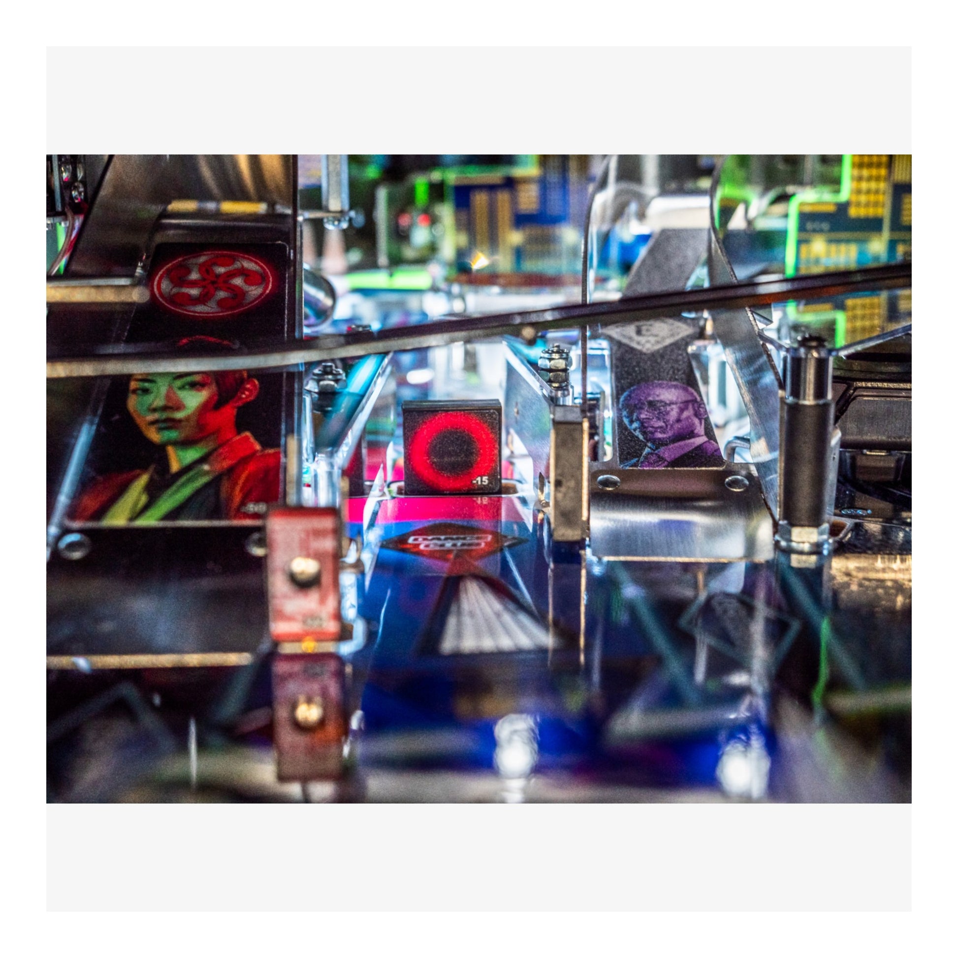 Close-up of a pinball machine with colorful artwork and reflective surface.