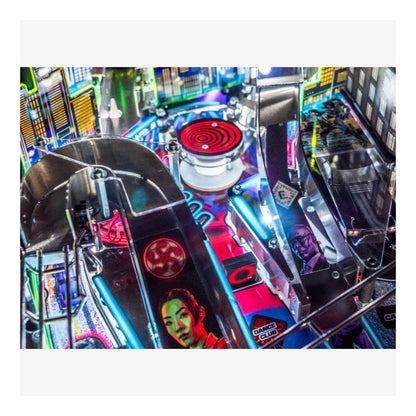 Close-up of a pinball machine with colorful artwork and vibrant lights.