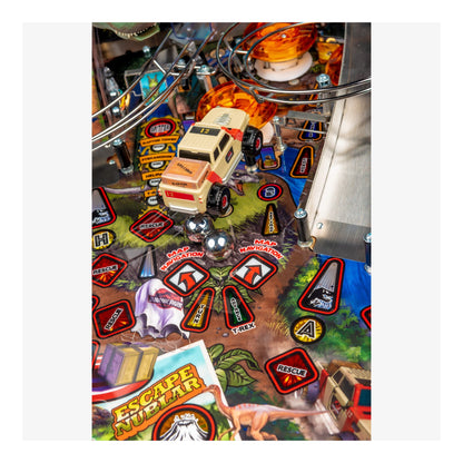 Close-up of a pinball machine with a vehicle and various game elements.