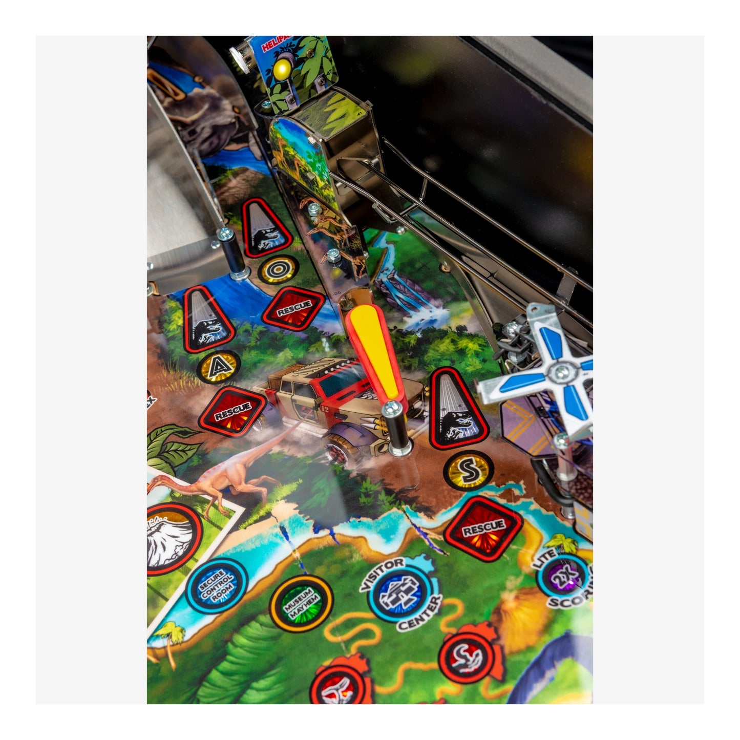 Close-up of a colorful pinball machine playing field with various symbols and designs.