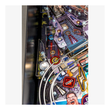 Close-up of a pinball machine with colorful artwork and lights.