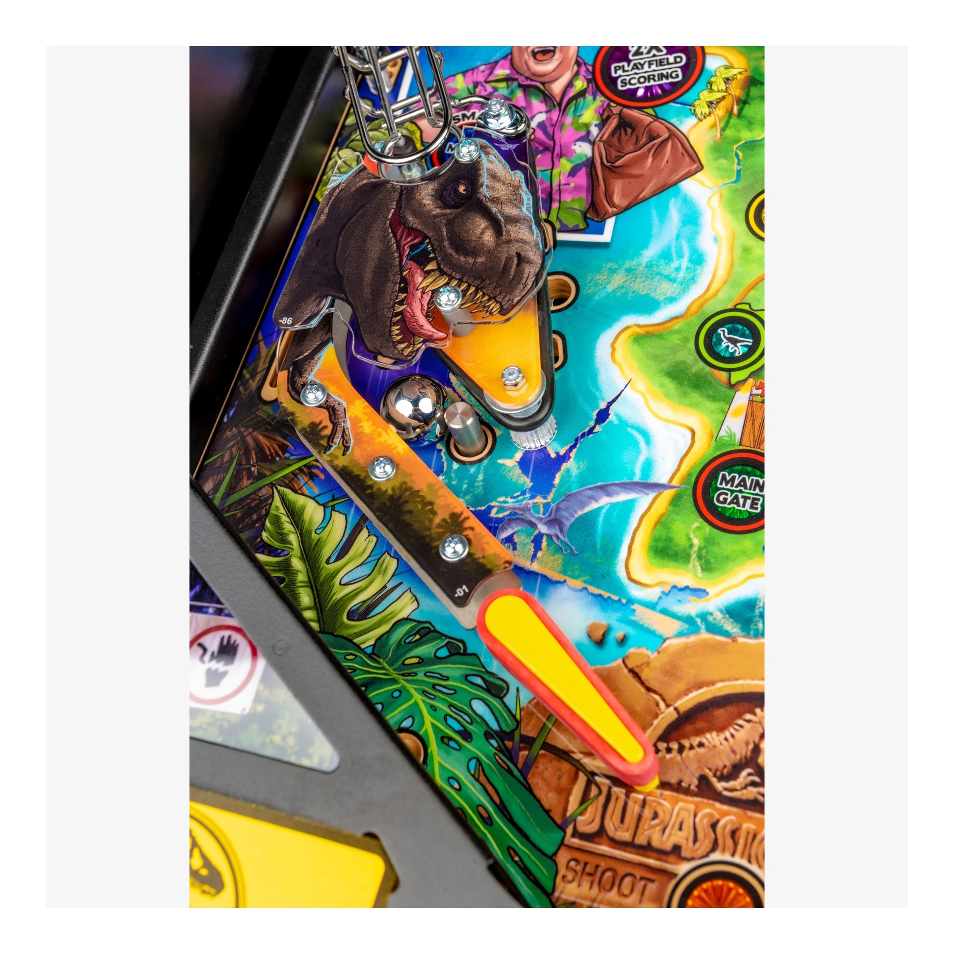 Close-up of a colorful pinball machine with dinosaur and tropical design
