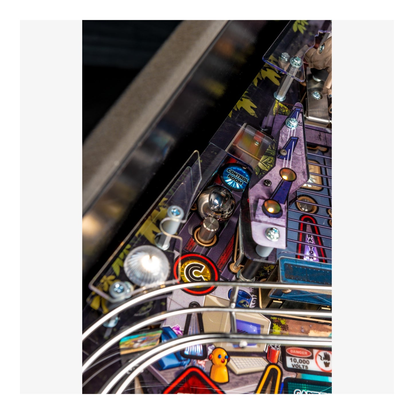 Close-up of a pinball machine with various components and lights.