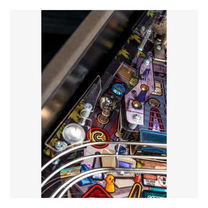 Close-up of a pinball machine with various components and lights.