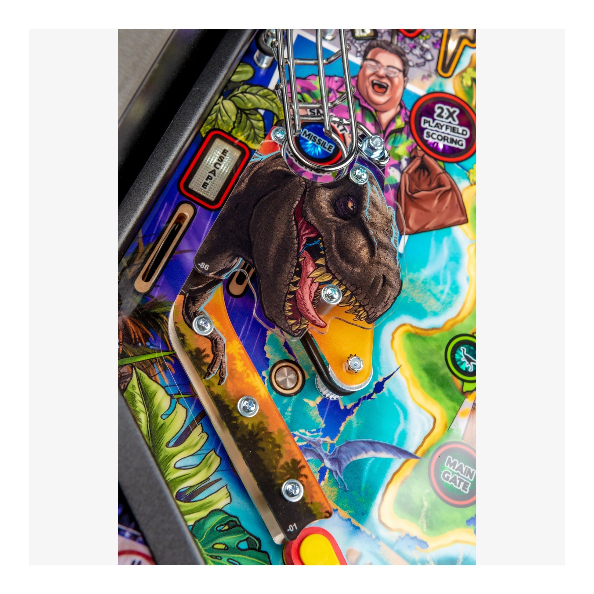 Close-up of a colorful pinball machine with a dinosaur illustration.