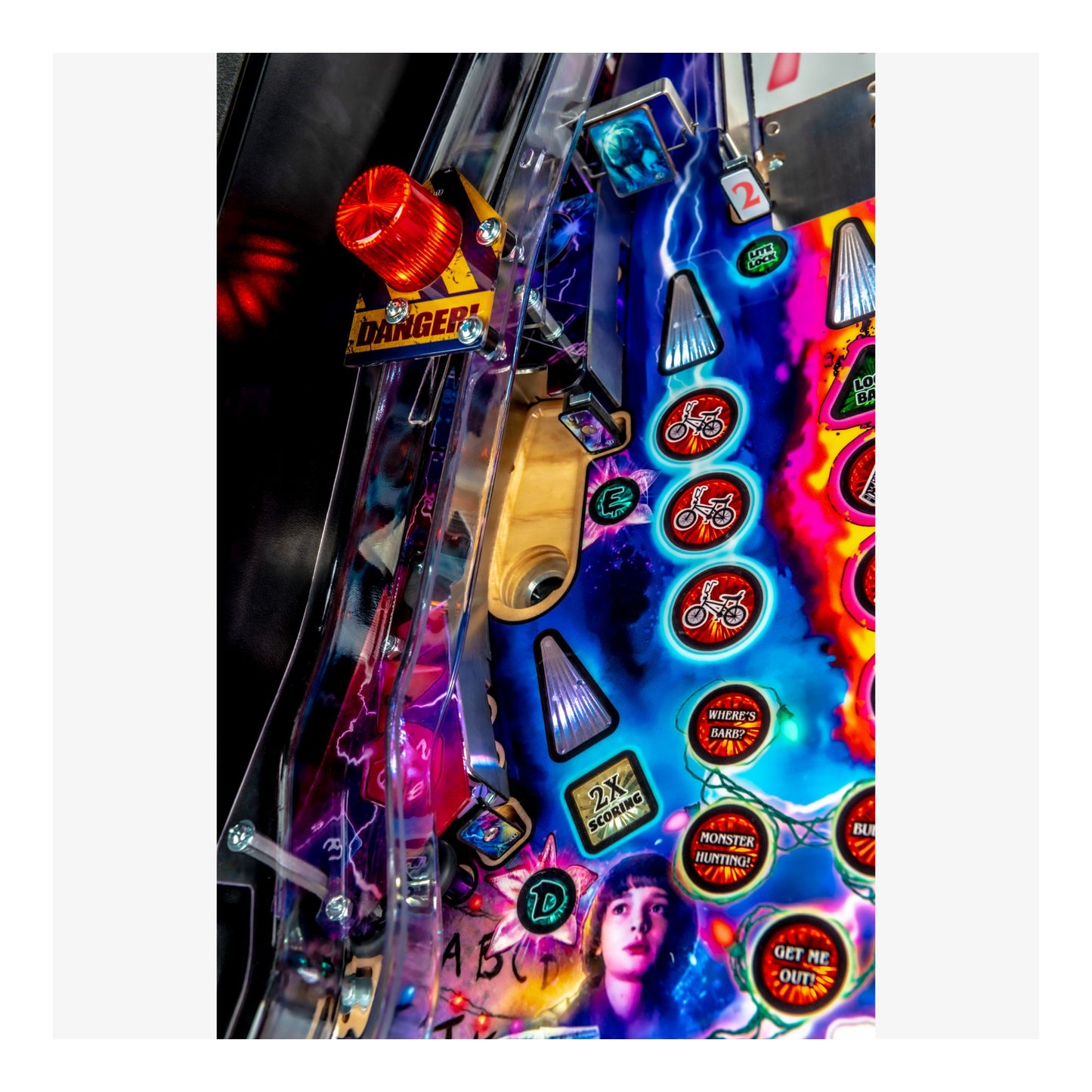 Close-up of a colorful pinball machine with various buttons and lights.