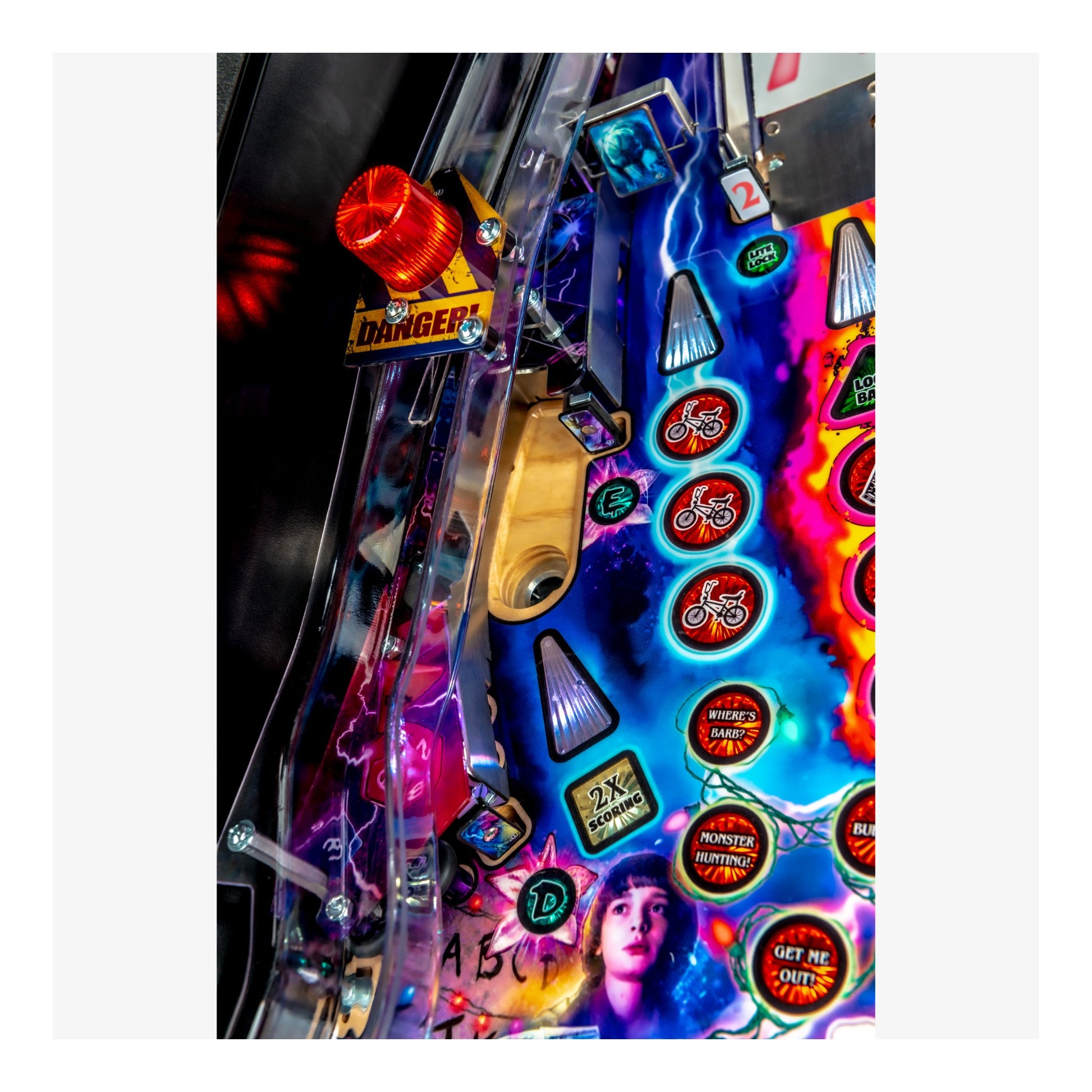 Close-up of a colorful pinball machine with various buttons and lights.