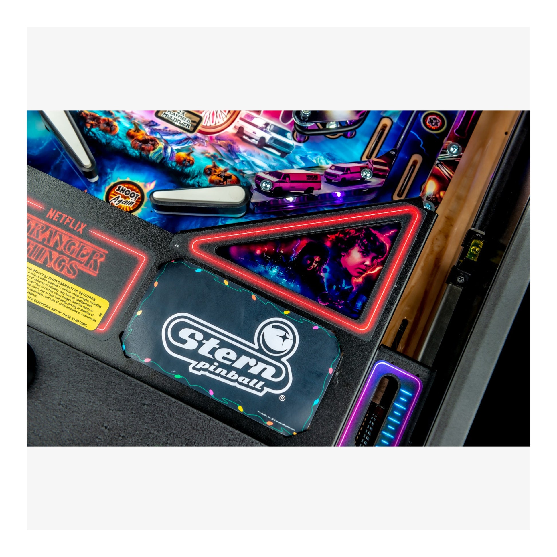 Close-up of a Stern pinball machine with colorful lights and branding.