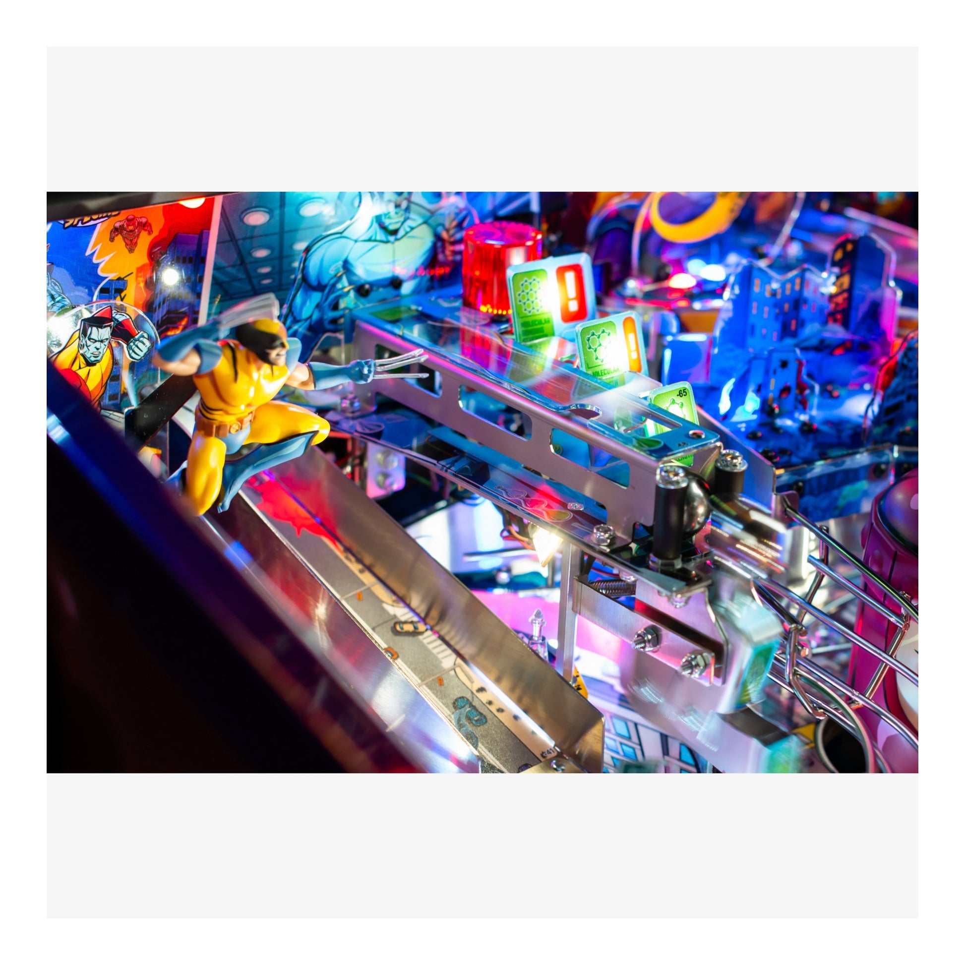Close-up of a colorful pinball machine with players and lights.