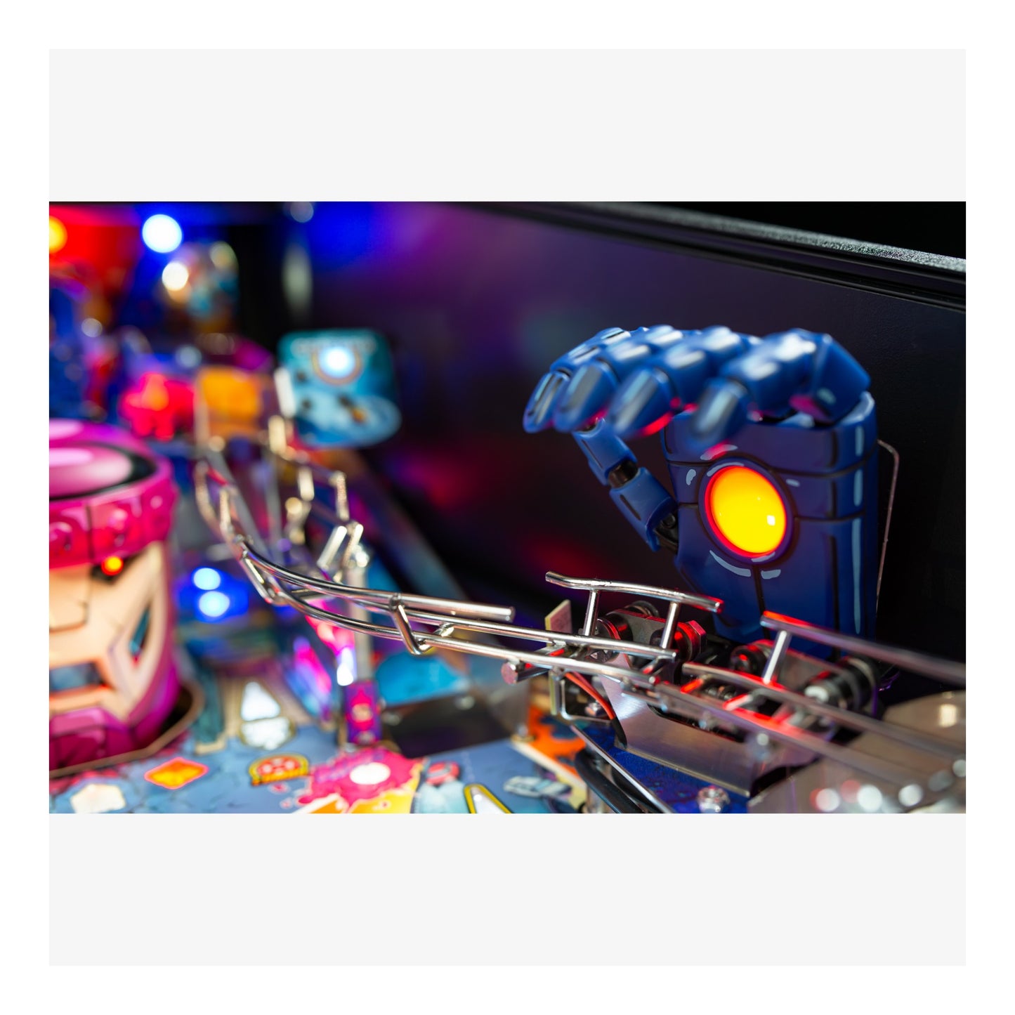 Close-up of a pinball machine with colorful playfield and mechanical components.