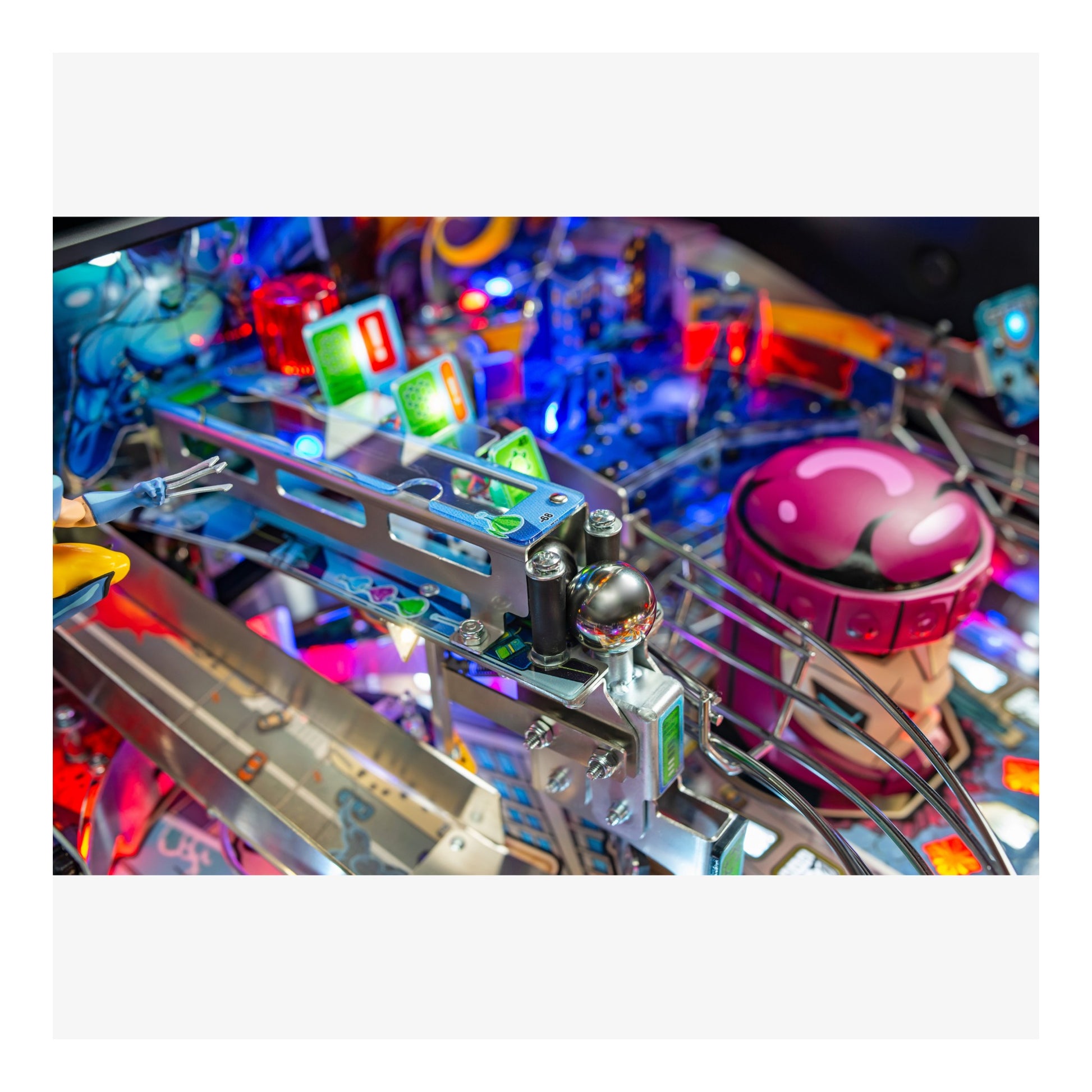 Close-up of a colorful pinball machine with vibrant lights and components.