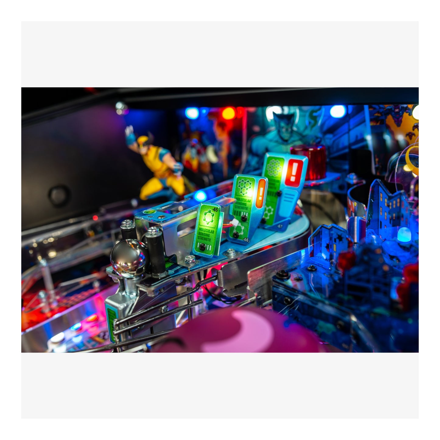 Close-up of a pinball machine with colorful lights and figures on a white background