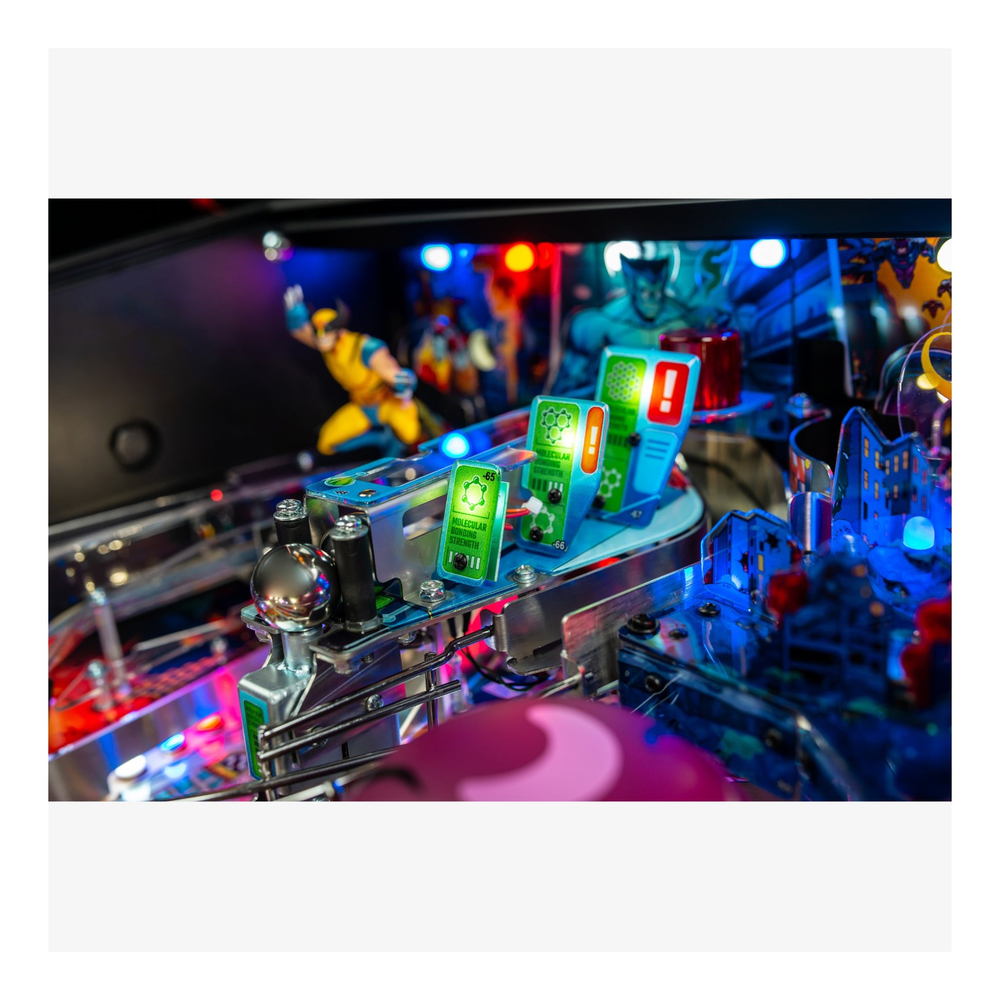 Close-up of a pinball machine with colorful lights and figures on a white background