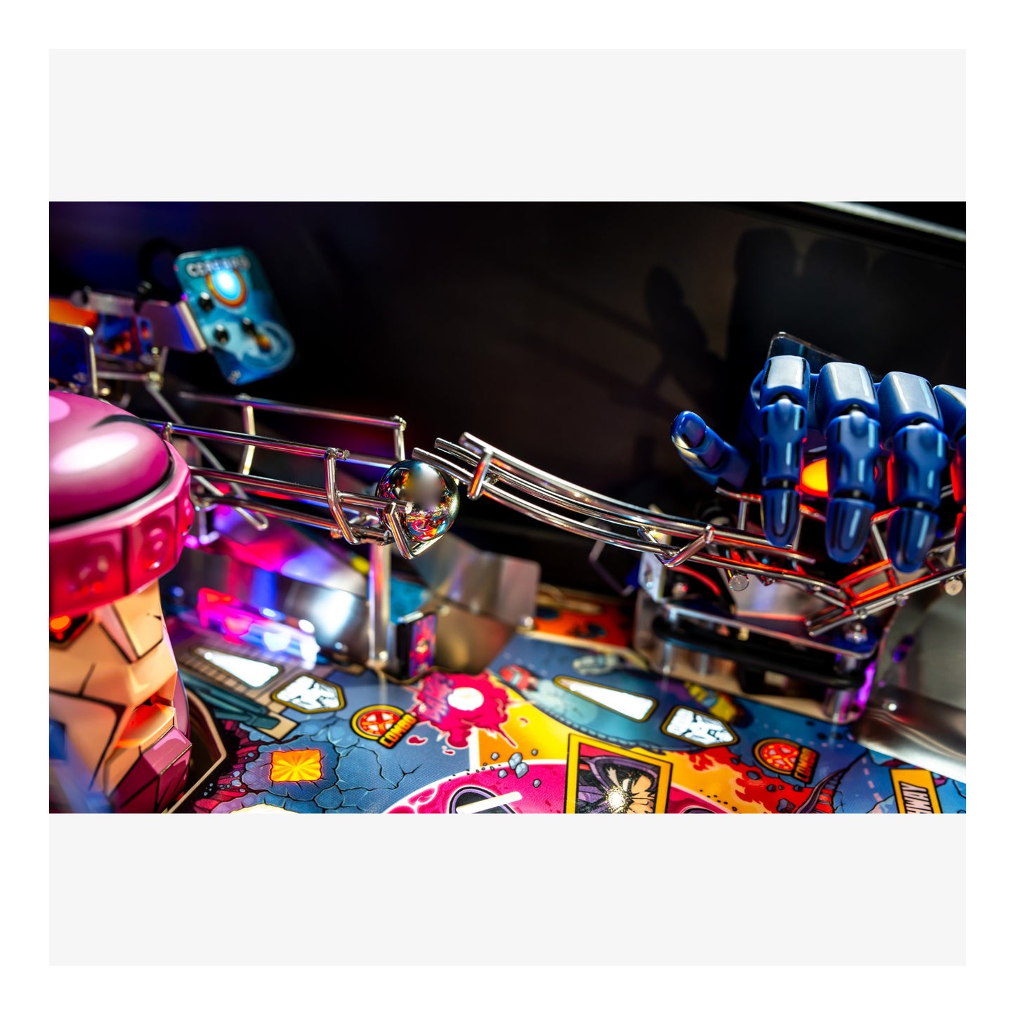 Close-up of a pinball machine with colorful playfield and mechanical components.