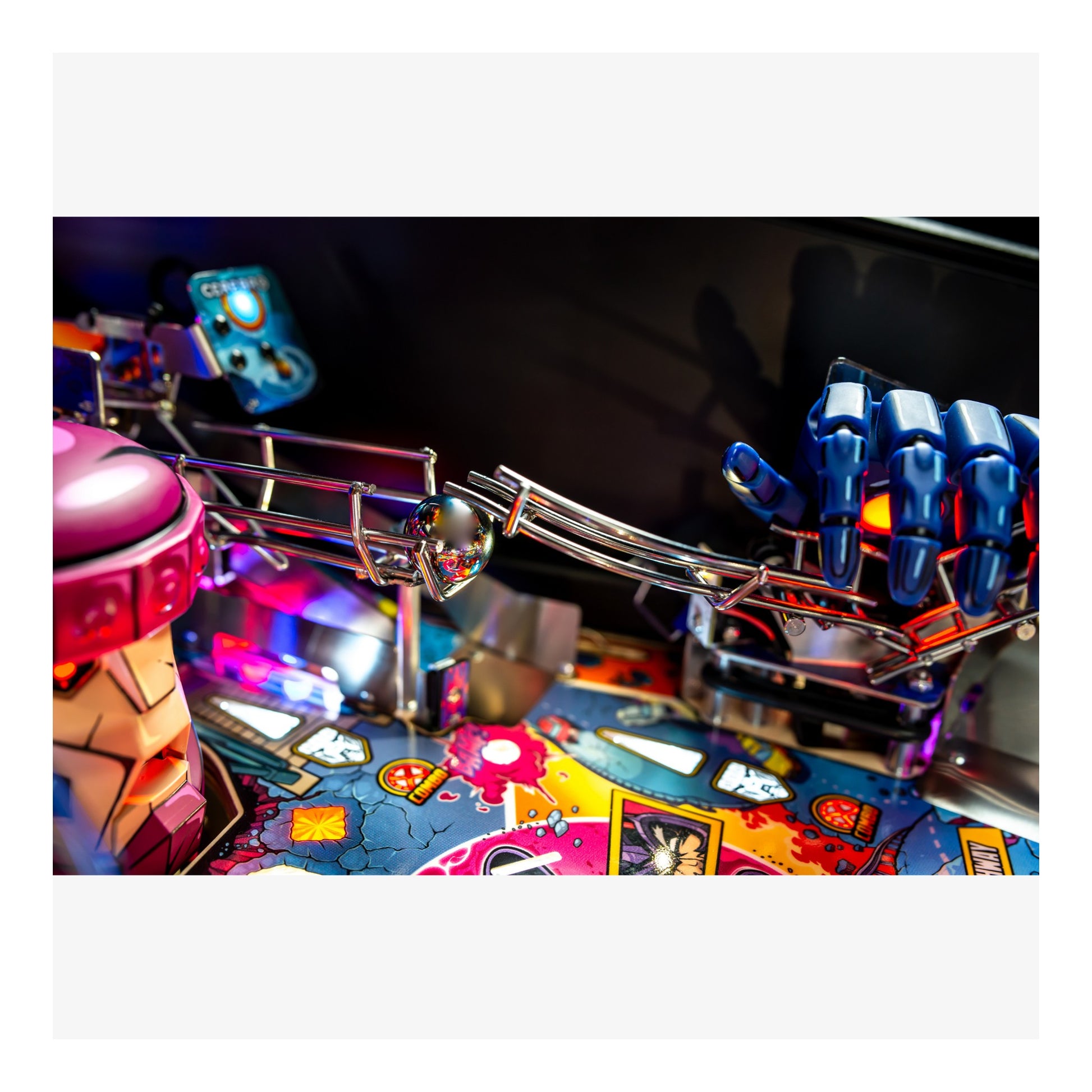 Close-up of a pinball machine with colorful playfield and mechanical components.