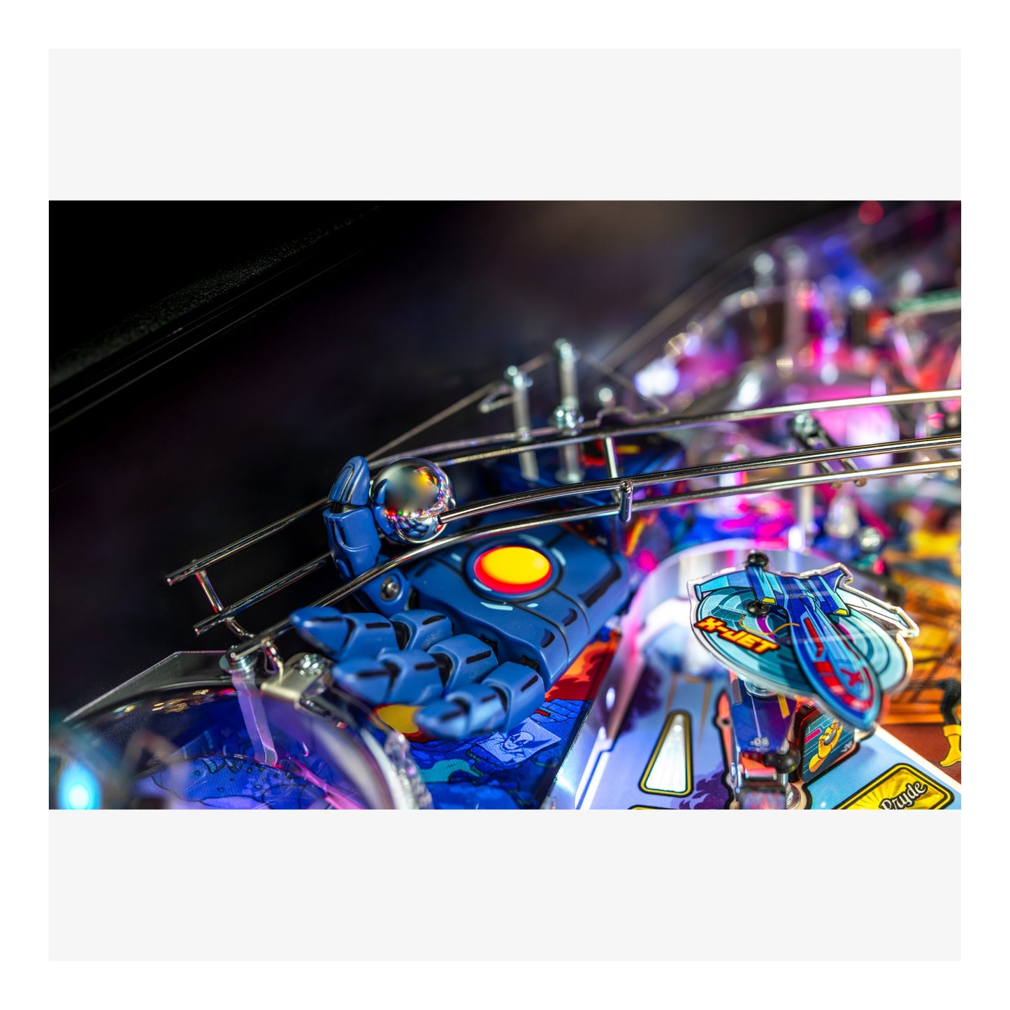 Close-up of a pinball machine with colorful playfield and lights.