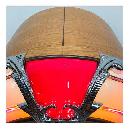 Close-up of a vehicle's headlight with a red lens and metallic frame.