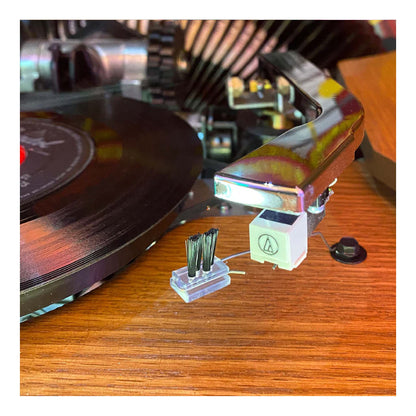 Close-up of a vinyl record player headshell on a wooden surface