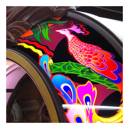 Colorful car rim wrap with a peacock design on a vehicle wheel.