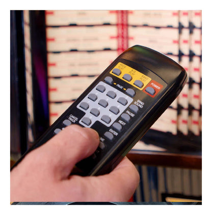 Hand holding a remote control with a blurred background