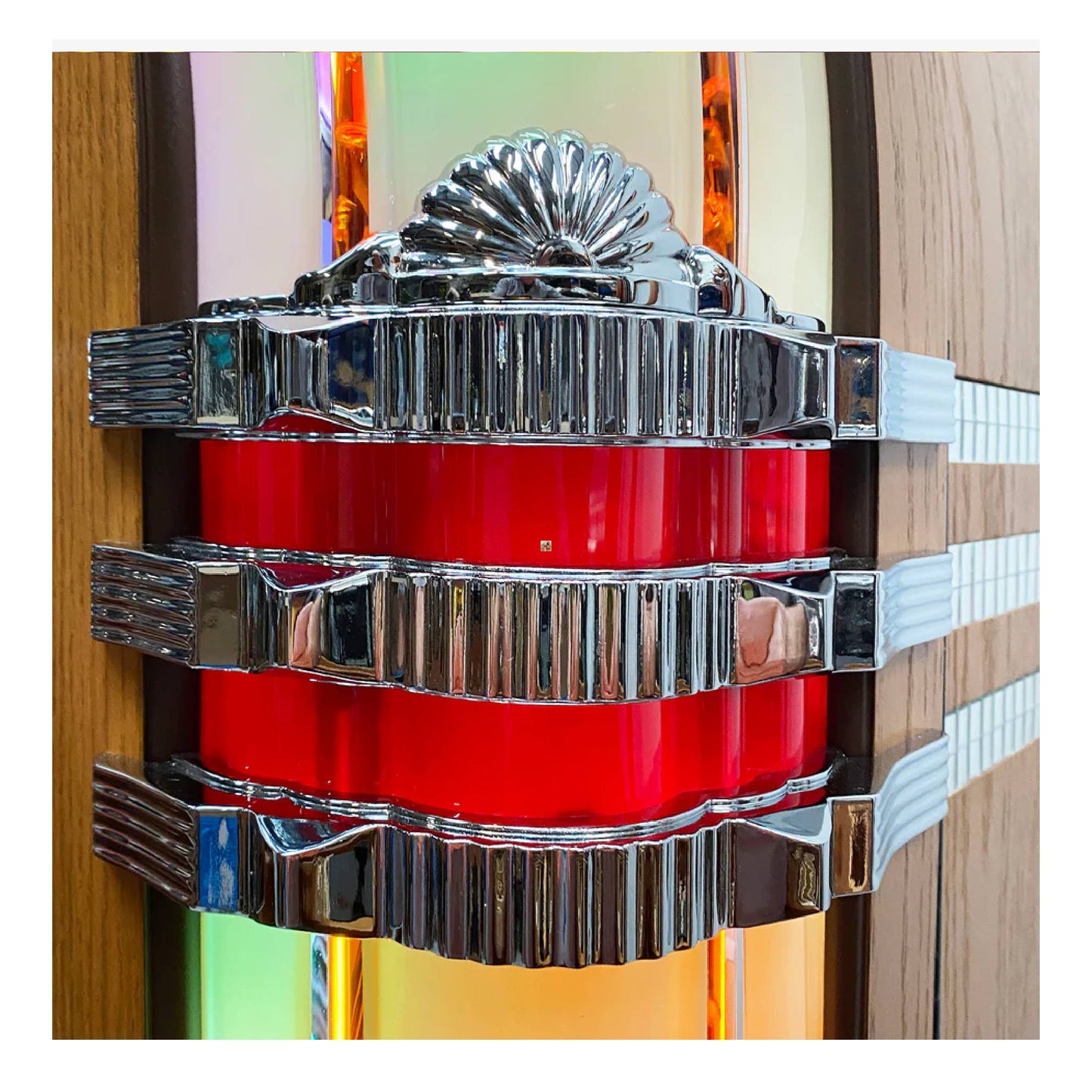 Decorative wall piece with red central component and silver metallic accents on a colorful background