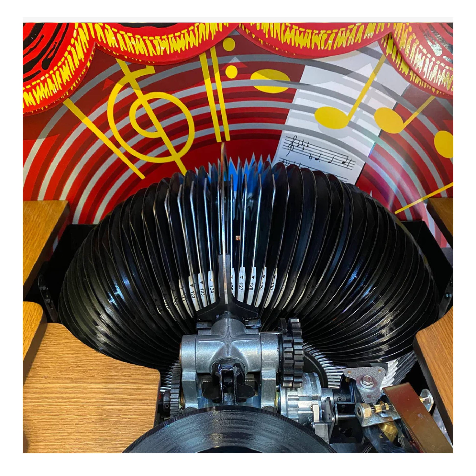 Close-up of a vintage record player needle against a colorful abstract background with musical notes.