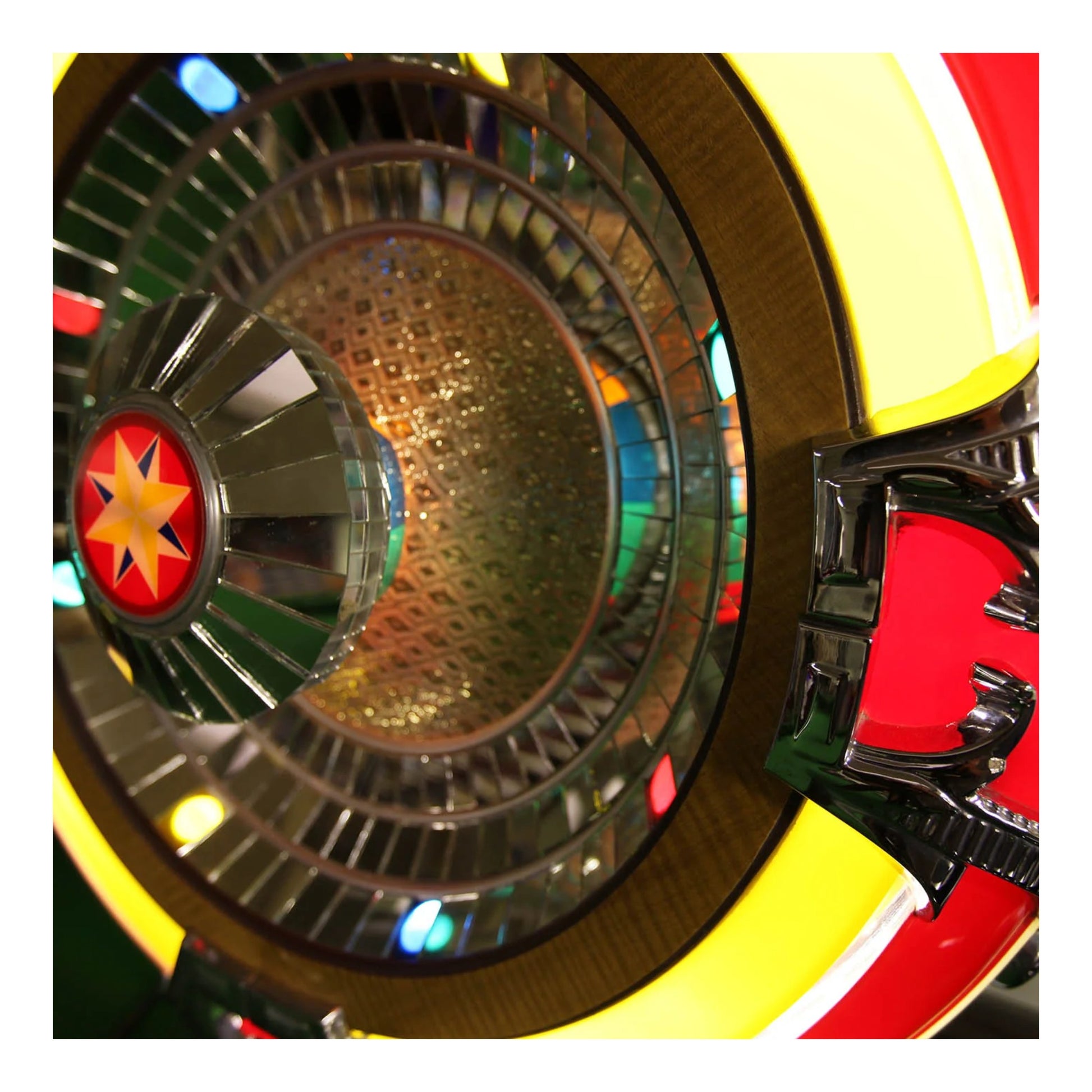 Close-up of a colorful wheel with a star design, likely from a carnival or amusement park ride.