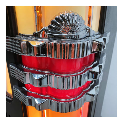 Close-up of a shiny, metallic car emblem with red center on a blurred background