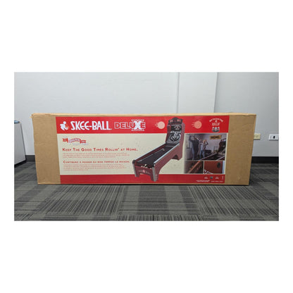 Box of Skee-Ball Deluxe game on a gray floor with white walls.