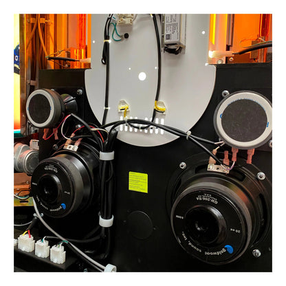 Close-up of a mechanical system with speakers and wiring in an industrial setting