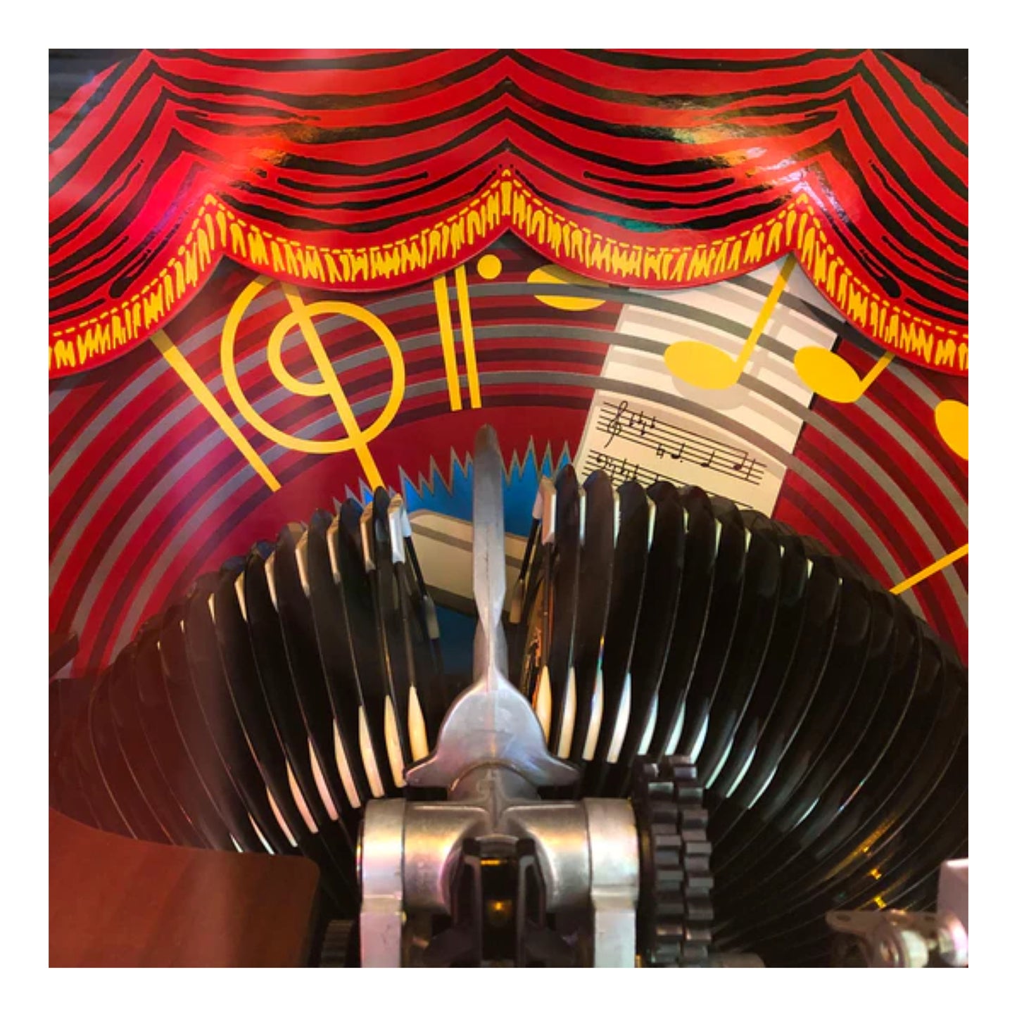 Decorative item with musical notes and a red curtain design