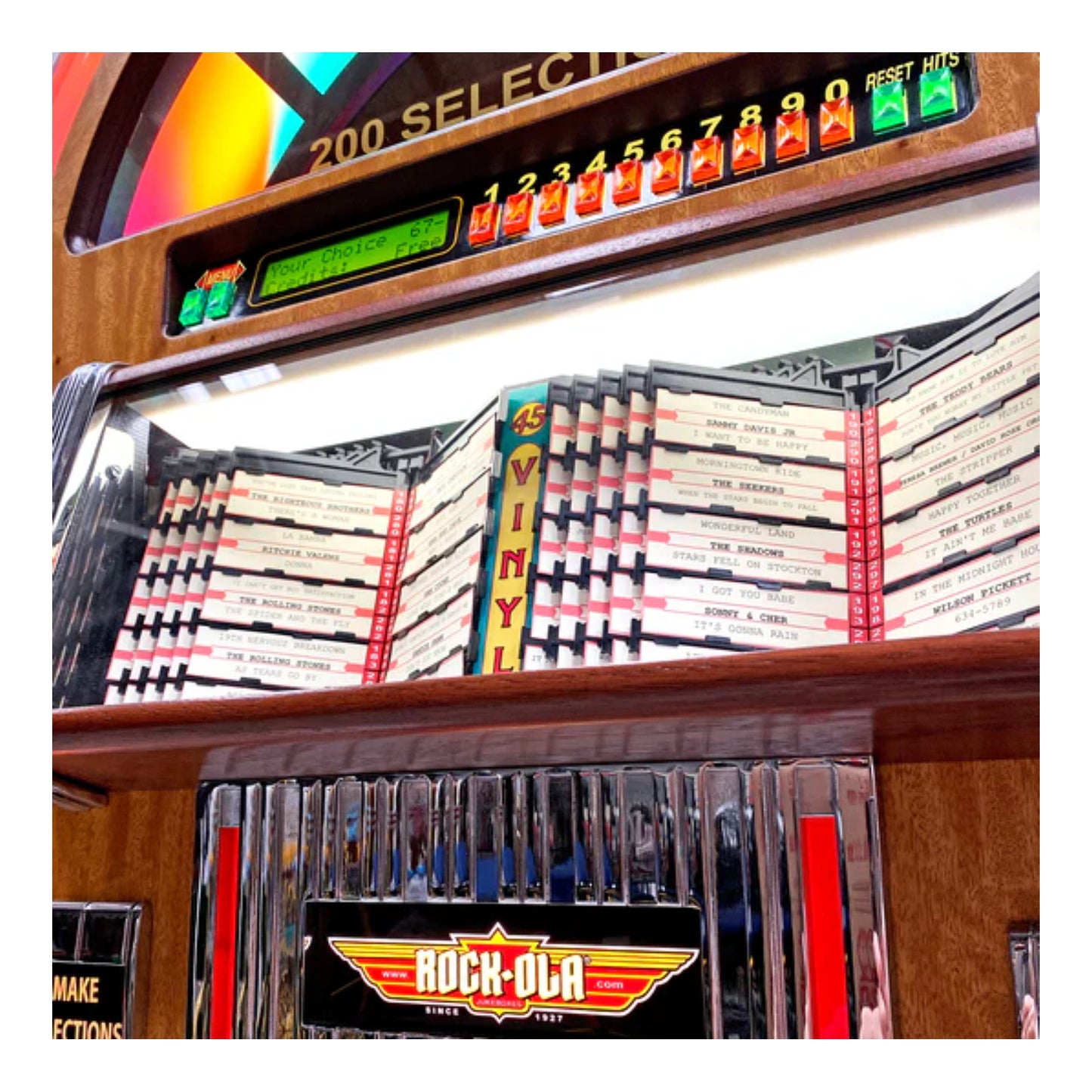 Vintage arcade machine with game cartridges and 'Rock-Ola' branding.