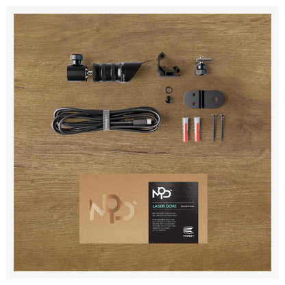 Collection of laser cut components and accessories on a wooden surface with a visible brand label.