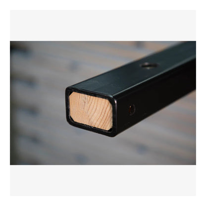 Close-up of a black metal bracket with wooden end on a blurred background