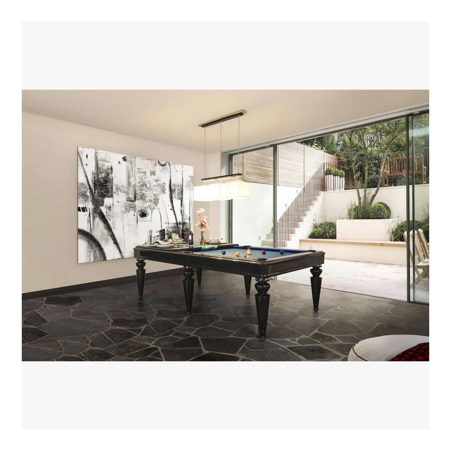 Modern living room with a pool table and large windows overlooking a garden.