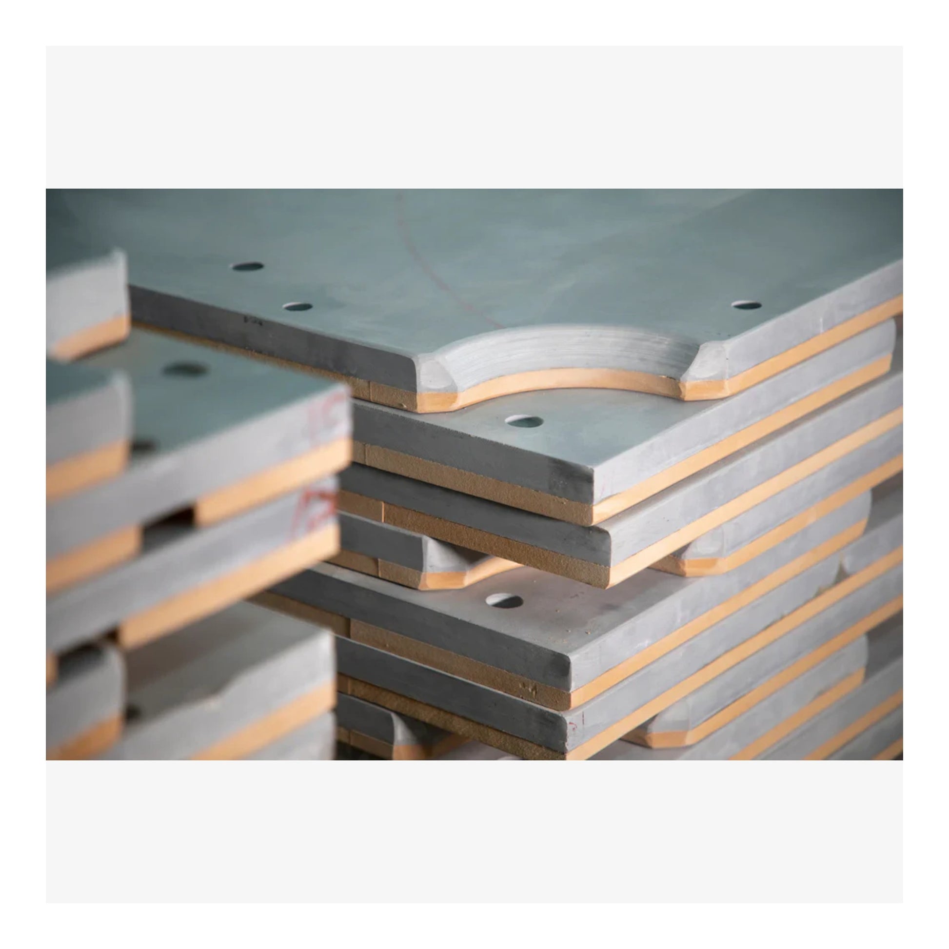 Stack of concrete or similar material slabs with a gray and brown color scheme.