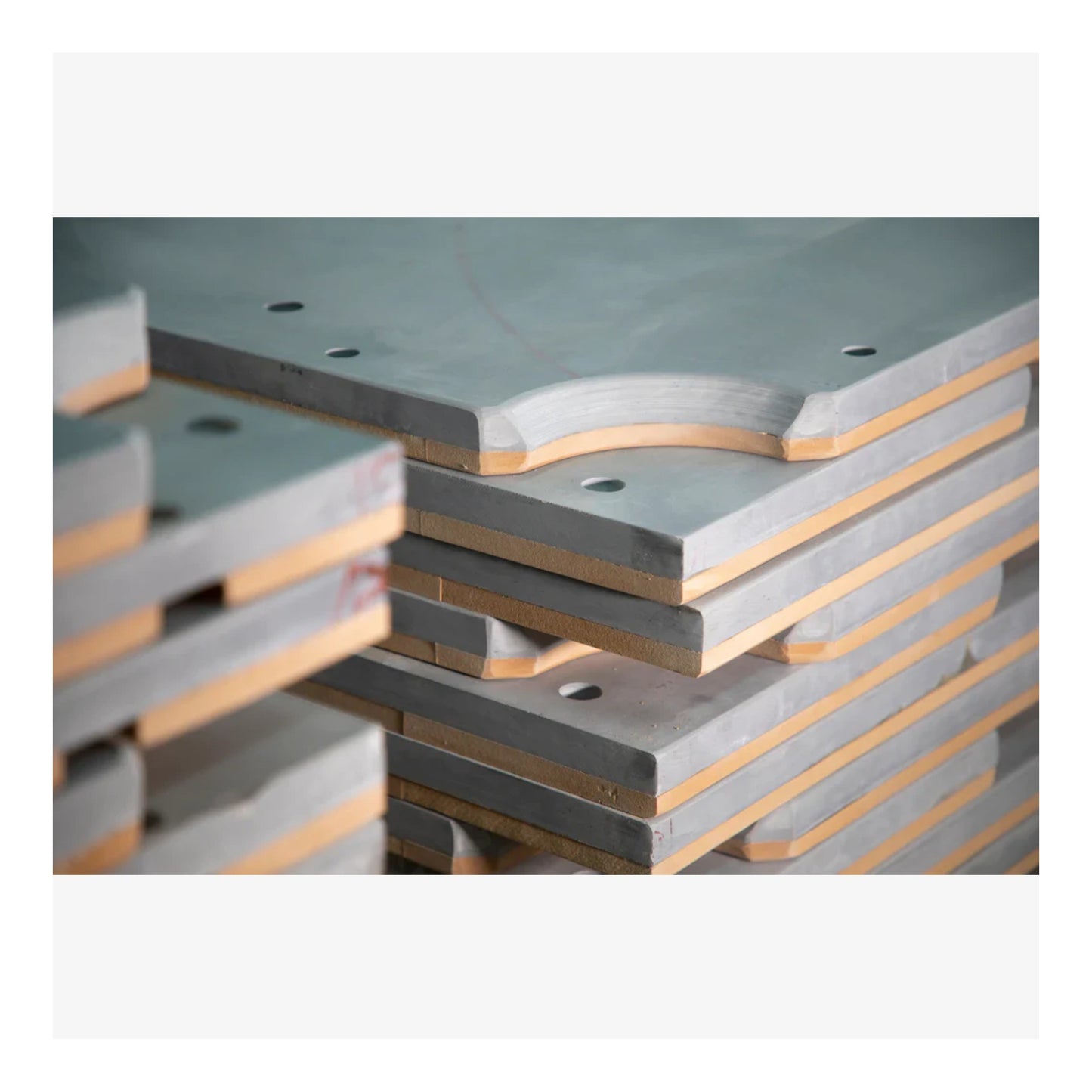 Stack of concrete or similar material slabs with a gray and brown color scheme.