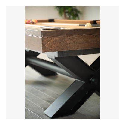 Wooden pool table with metal legs on a wooden floor.